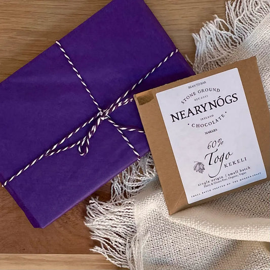 A book subscription box with chocolate - image shows a beautifully wrapped book, plus a bar of luxury artisan chocolate. typical of what would be received in this monthly gift for readers and book lovers