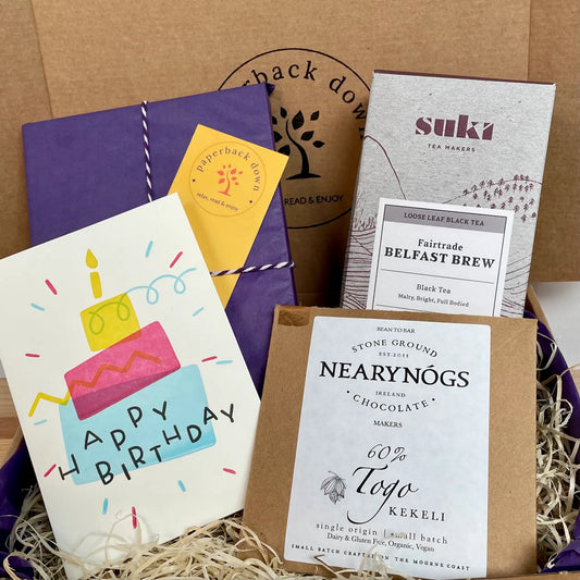 A Birthday Gift Box for Book-lovers, featuring a new book from your chosen genre, Suki's iconic Belfast Brew looseleaf tea, NearyNogs Chocolate and a beautiful birthday card.