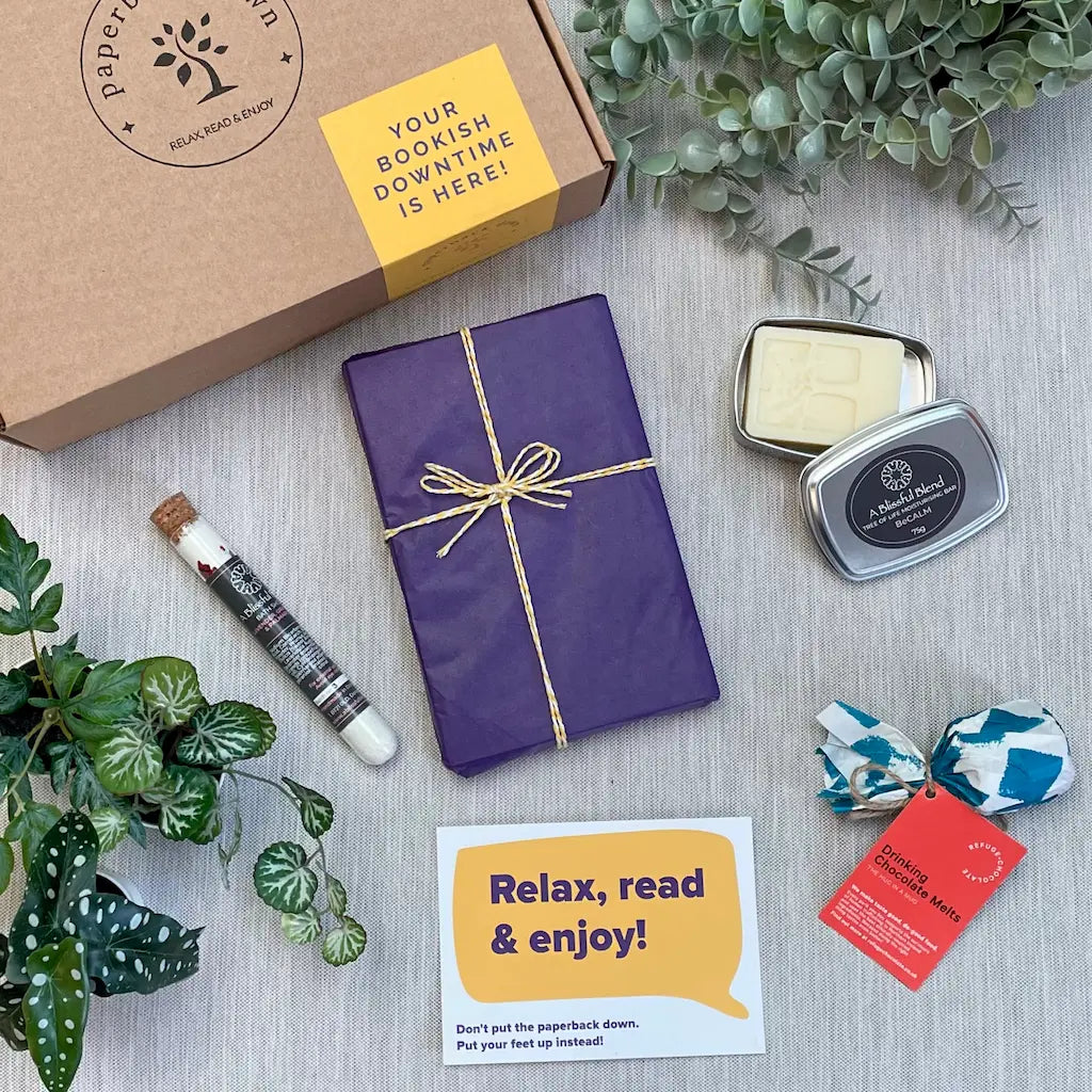 A gift box designed to encourage an evening of self-care and bookish bliss - the image shows a beautifully wrapped book, bath salts and a soothing moisturising bar.