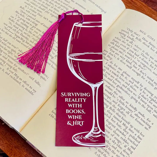 Relatable and funny bookmark for anyone menopausal or peri-menopausal, in a dark red background with a wine glass design and text saying 'Surviving reality with books, wine and HRT'.