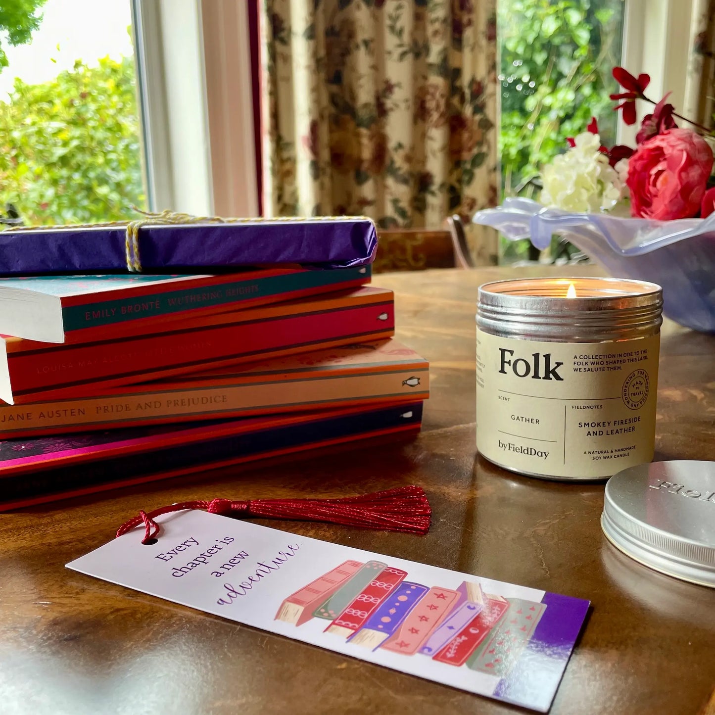 Image shows a classic book and candle gift set for book lovers. Pictured is a stack of collectible Penguin English Library paperbacks, classic and timeless fiction from across the century. Also shown is a Field Day Gather Folk Tin Candle, hand poured in County Down