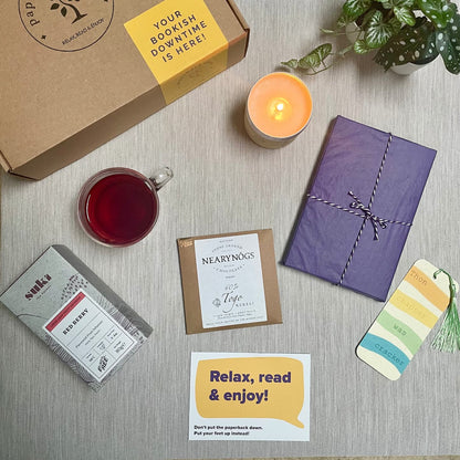 Image shows our Tea-Lovers Gift Box which contains a beautifully wrapped new book of your choice; a full-sized box of Suki Tea, a Belfast-based specialist tea company; a bar of NearyNogs Chocolate, and a new bookmark.