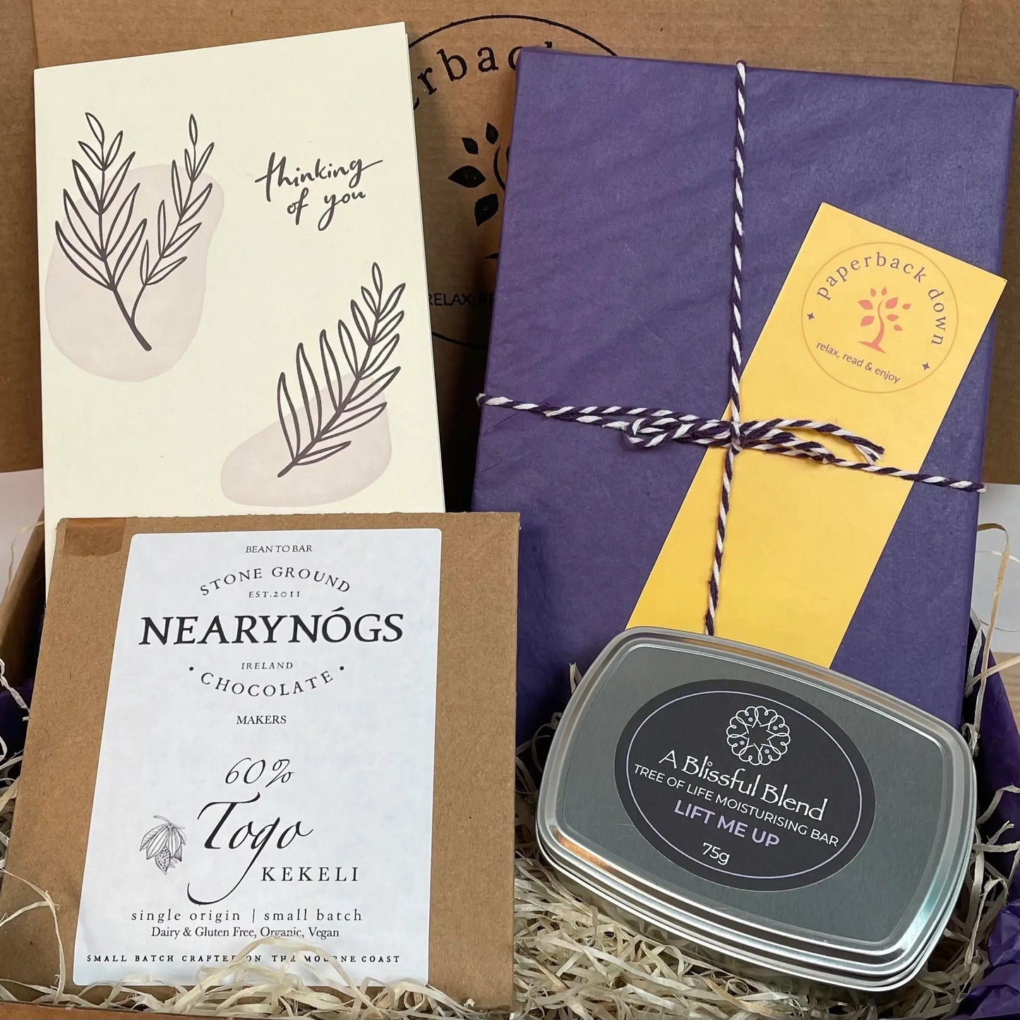 Thinking of You Gift Box including a beautifully wrapped new book, a delicious bar of NearyNogs chocolate, a moisturising lotion bar from A Blissful Blend and a handwritten notecard with your personalised message.