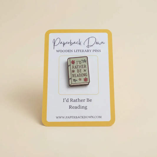 Wooden literary pin with 'I'd Rather Be Reading' design on a card, branded 'Paperback Down'.